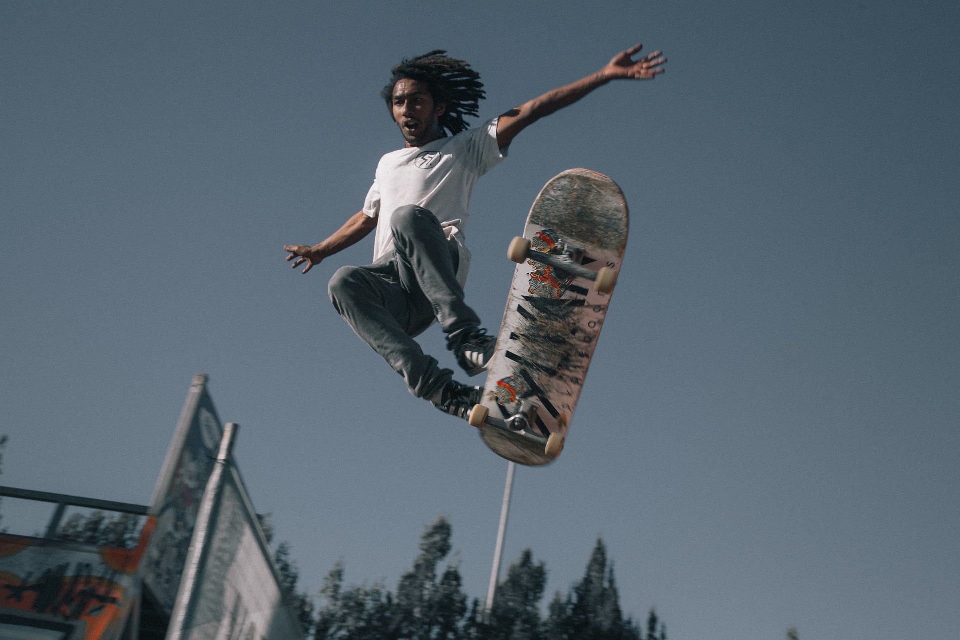 A skateboarder losing control of his board mid-trick